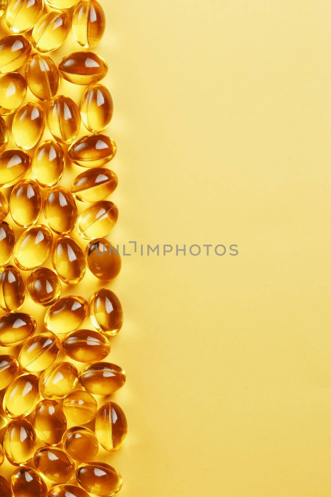 Capsules in a shell with Omega-3 fish oil on a yellow background and a place for text by AlexGrec