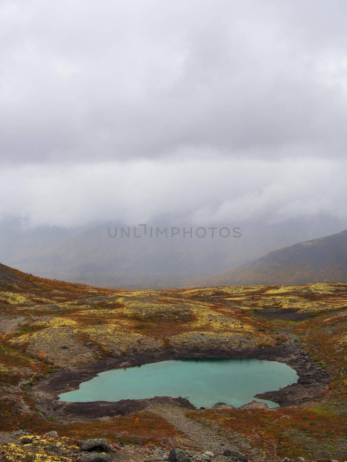 Lake with turquoise water in the mountains in autumn on a cloudy day. view from above. photo