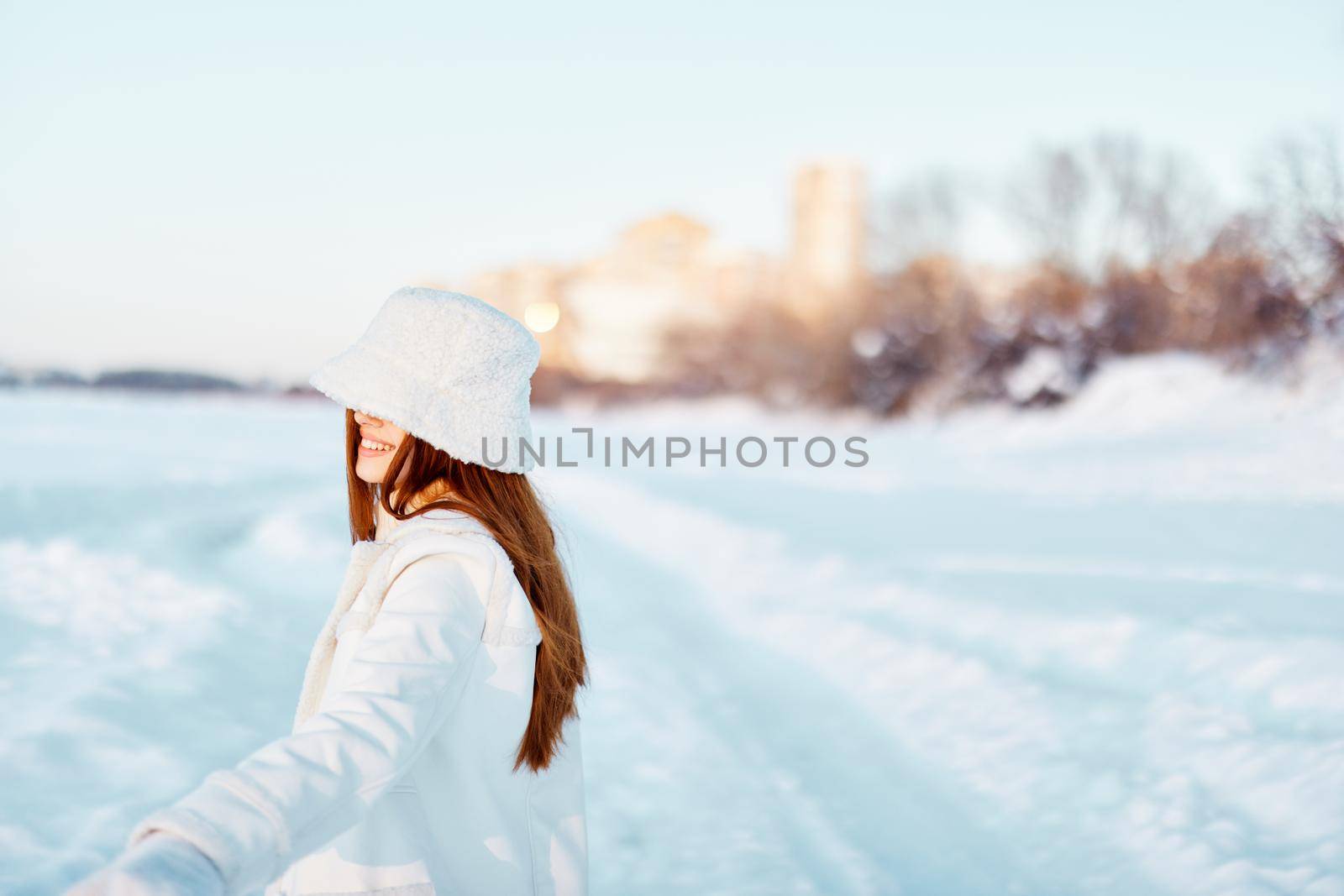 beautiful woman in a white coat in a hat winter landscape walk travel. High quality photo