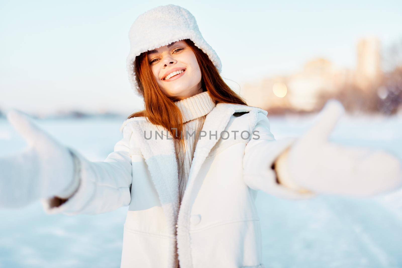 beautiful woman in a white coat in a hat winter landscape walk travel. High quality photo