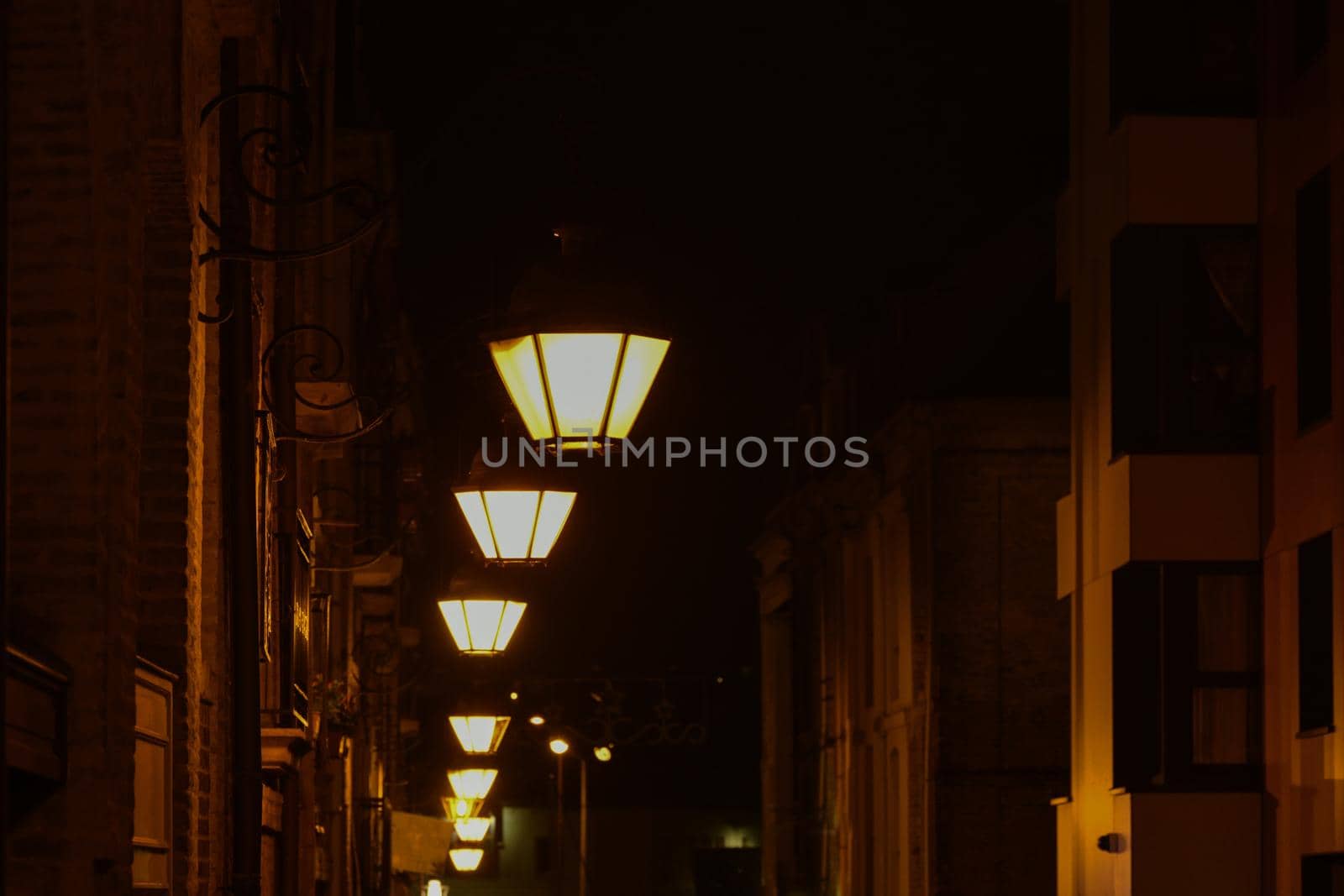 Vintage lamps shine on the street at night