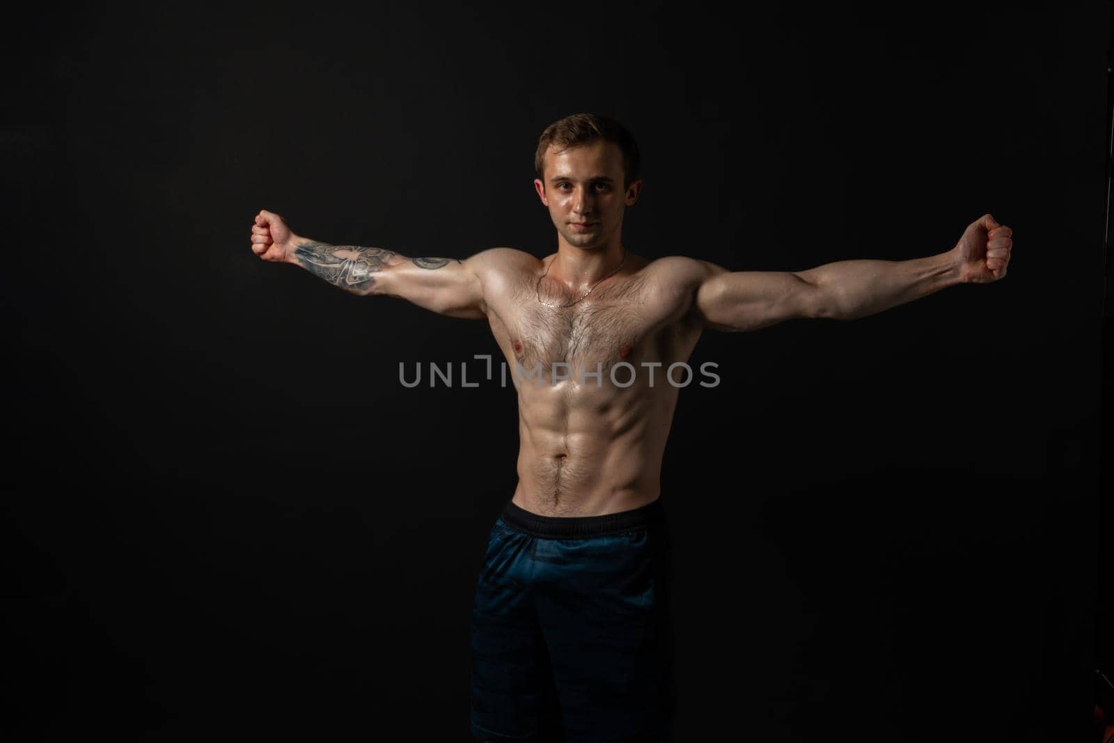 Man on black background keeps dumbbells pumped up in fitness bodybuilding chest torso, body strong bodybuilder hand, person lifestyle. Attractive sportive gym fit