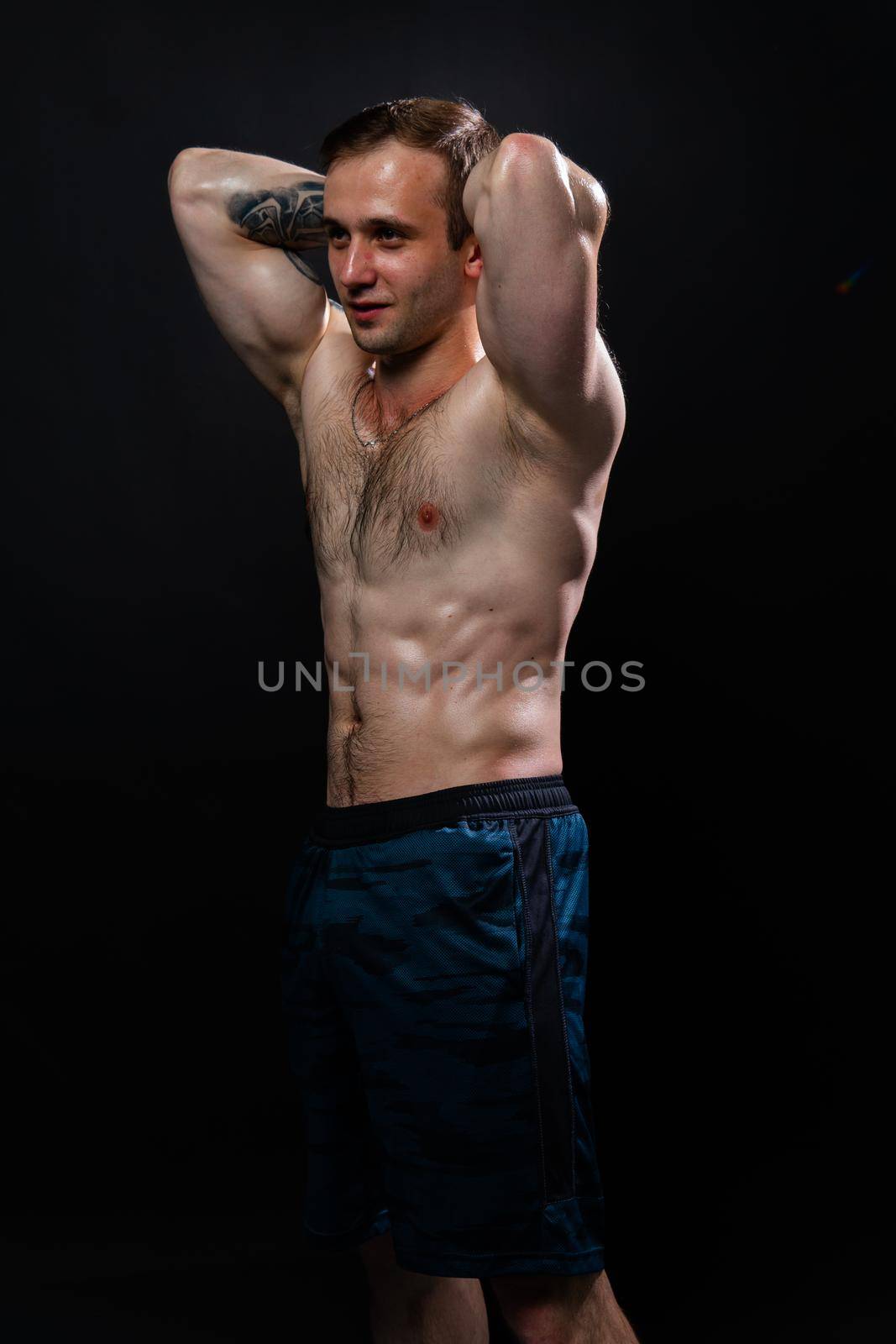 Man on black background keeps dumbbells pumped up in fitness muscle sexy black, training man bodybuilder dumbbell, male weightlifting. Young skin adult, gym fit hands behind your head a beautiful press