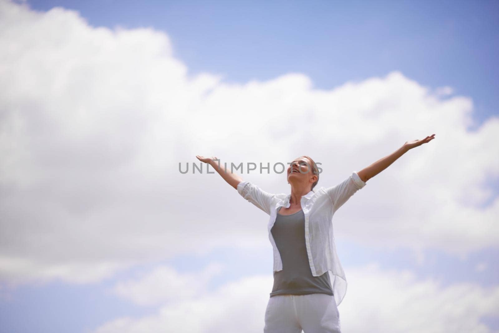 A mature woman with arms outstretched.