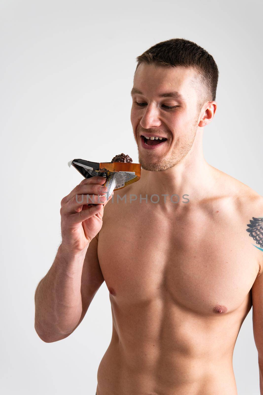 Man eats protein bar on white background isolated protein diet nutrition athlete caucasian, calorie. People ABS, muesli female
