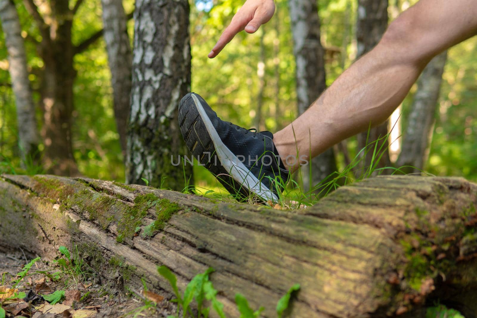 A young enduring athletic athlete is doing stretching in the forest outdoors, around the forest, oak trees.run nature, outdoor athletic wellness marathon, woods outside. running, runners stretches