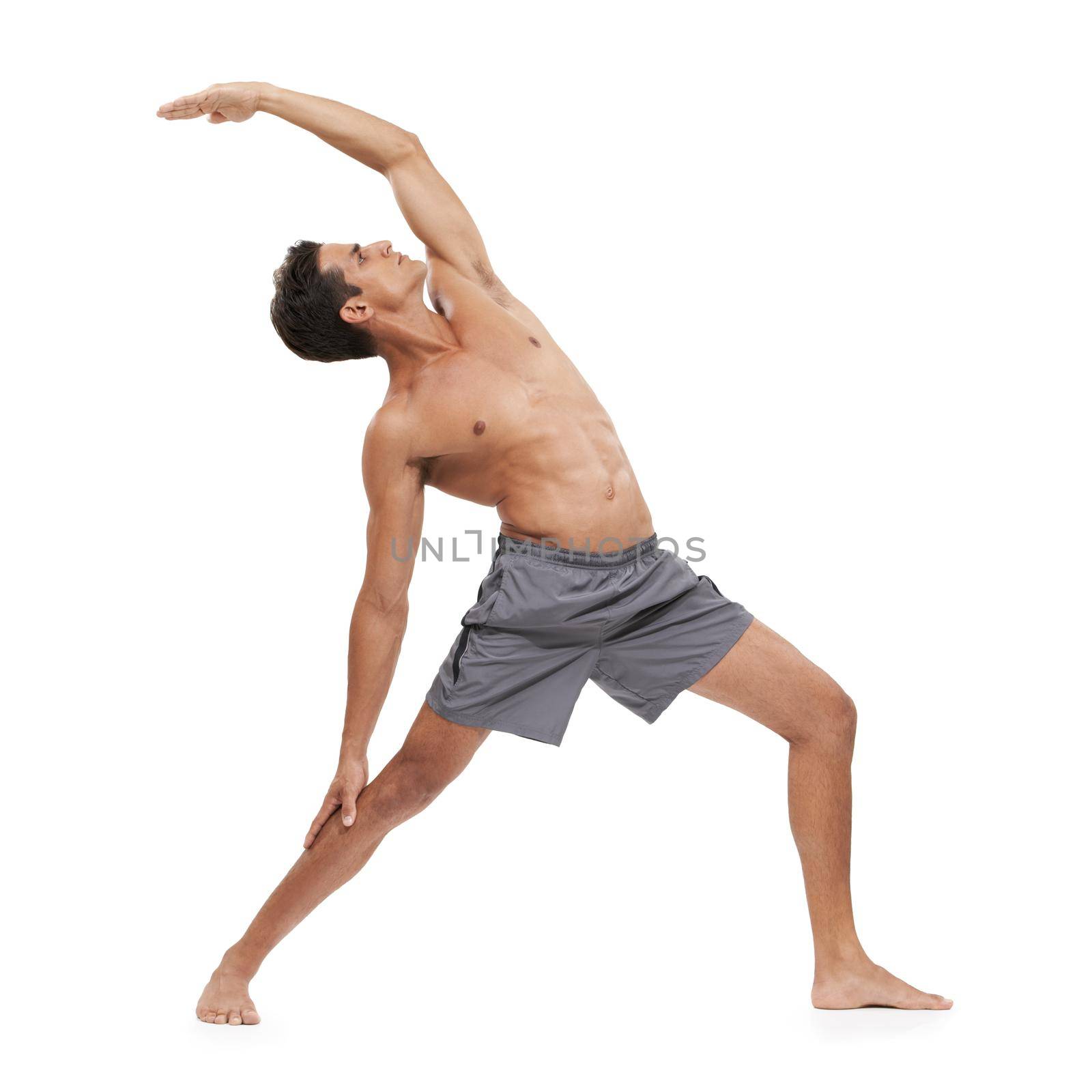 Staying focussed with yoga. A handsome young man doing yoga on a white background. by YuriArcurs