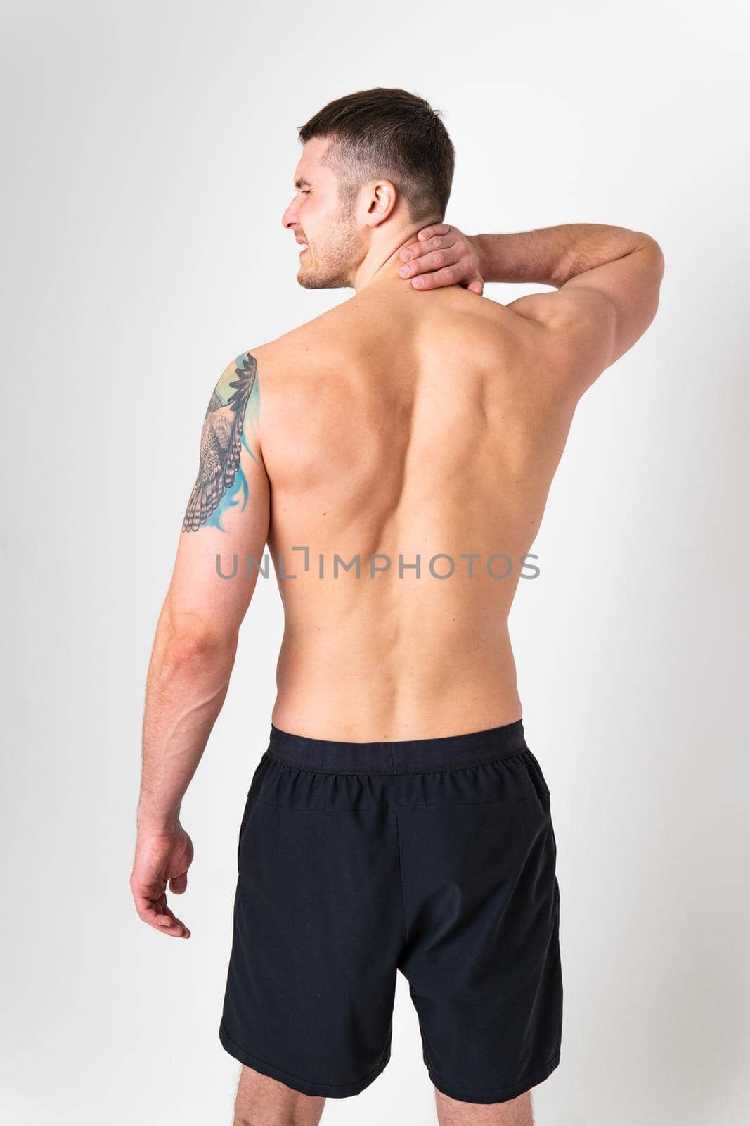 The muscles of the neck in a man on a white background are hurt back body cramp person man young stress, hand expression. Touching red sickness, disease suffer attractive