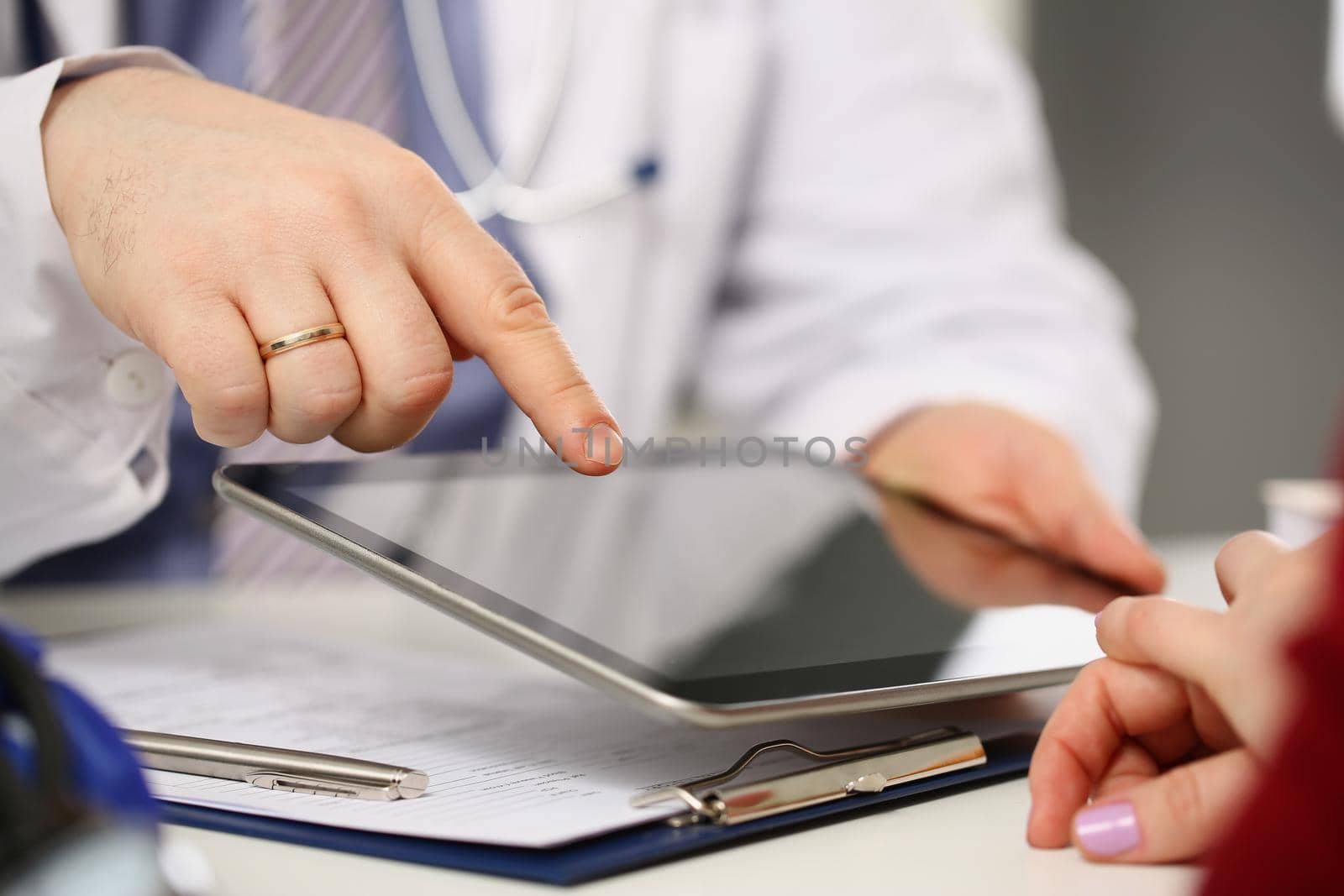 Close-up of man doctor consult woman patient, point with finger on tablet device. Client listen to instructions of specialist. Healthcare, mockup concept