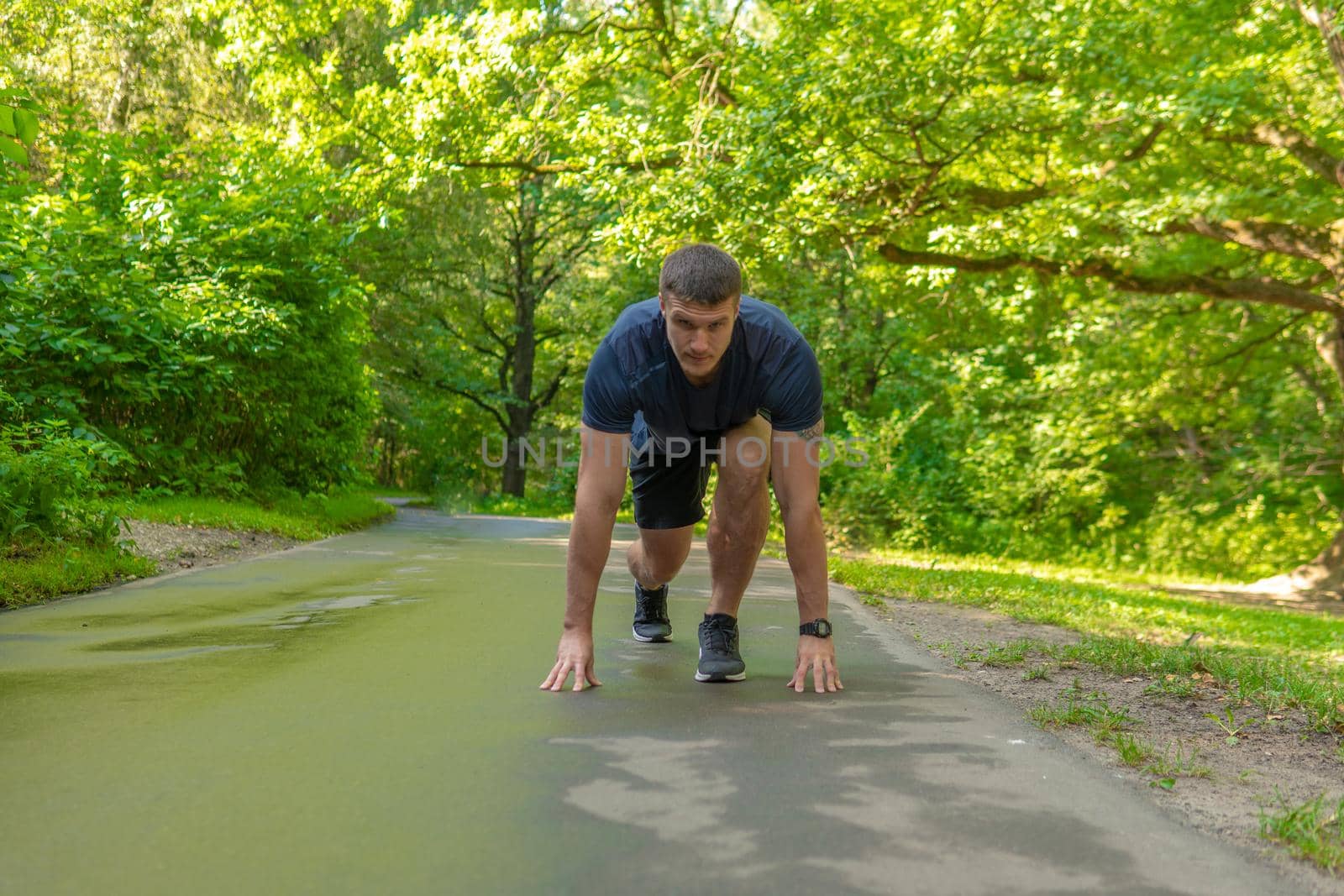 A man athlete runs in the park outdoors, around the forest, oak trees green grass young enduring athletic athlete runner nature, lifestyle outdoor young legs male, man. Adult energy running, stretching stretches