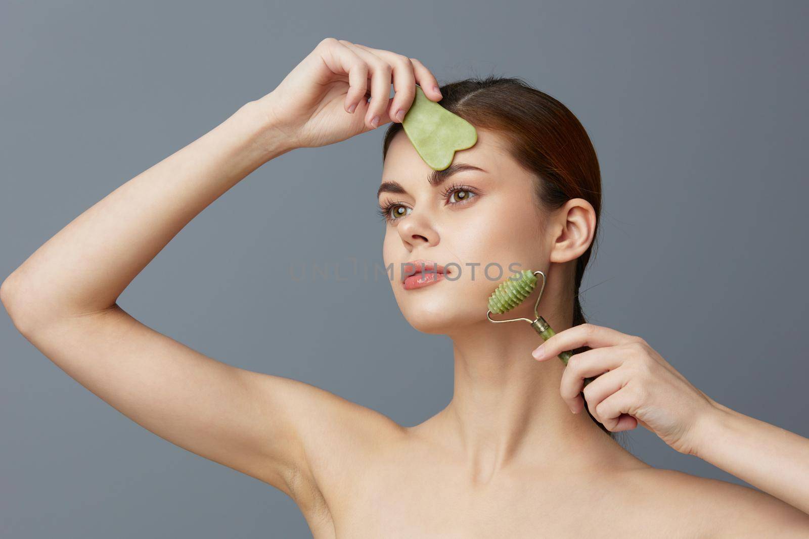 young woman face scraper wrinkle smoothing bare shoulders isolated background by SHOTPRIME