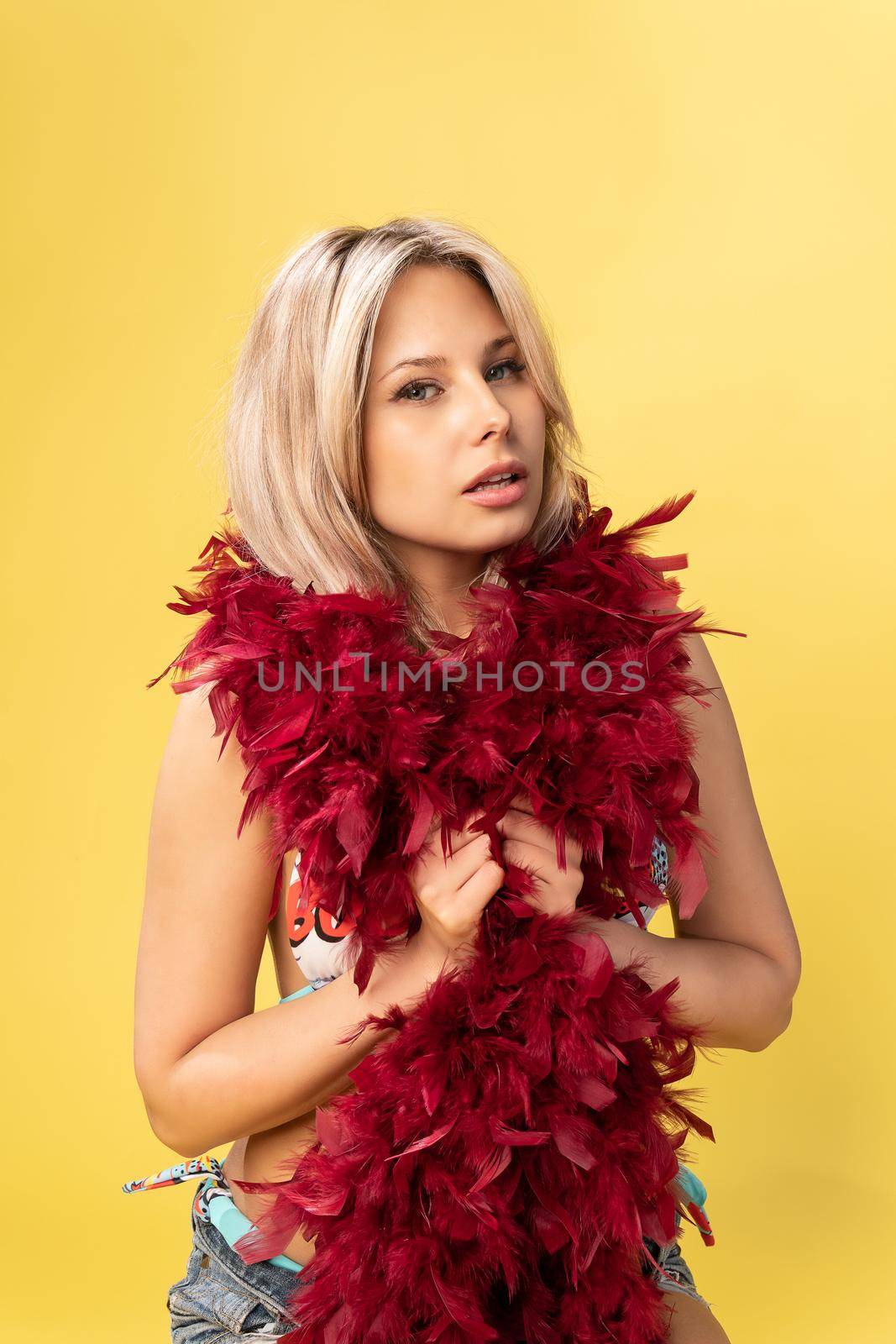 Girl in the hands of boa red-colored chicken feathers blonde boa style hair light elegant glamour, up Care lips ot, emotion vogue party expression retro