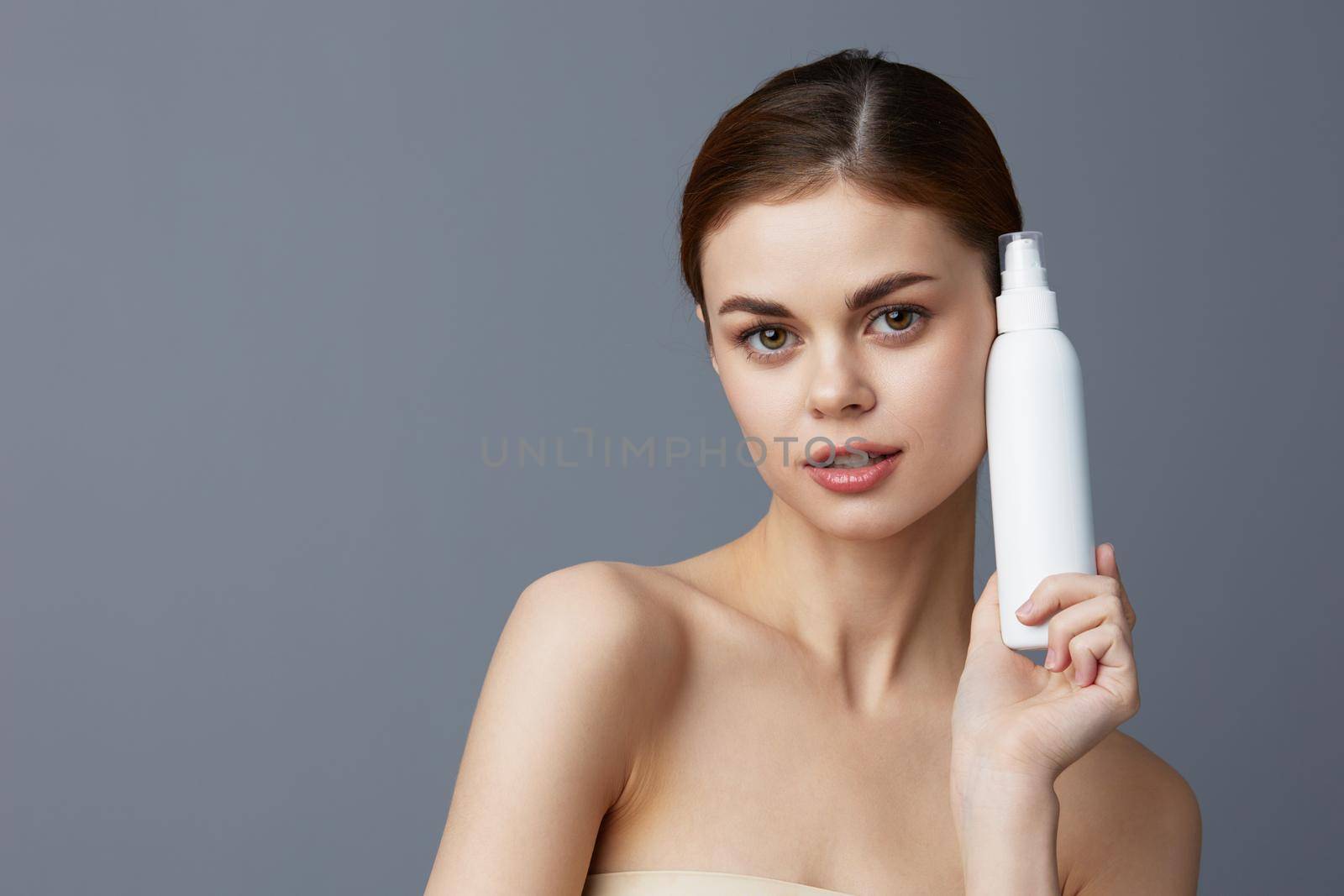 young woman body lotion rejuvenation cosmetics Gray background. High quality photo
