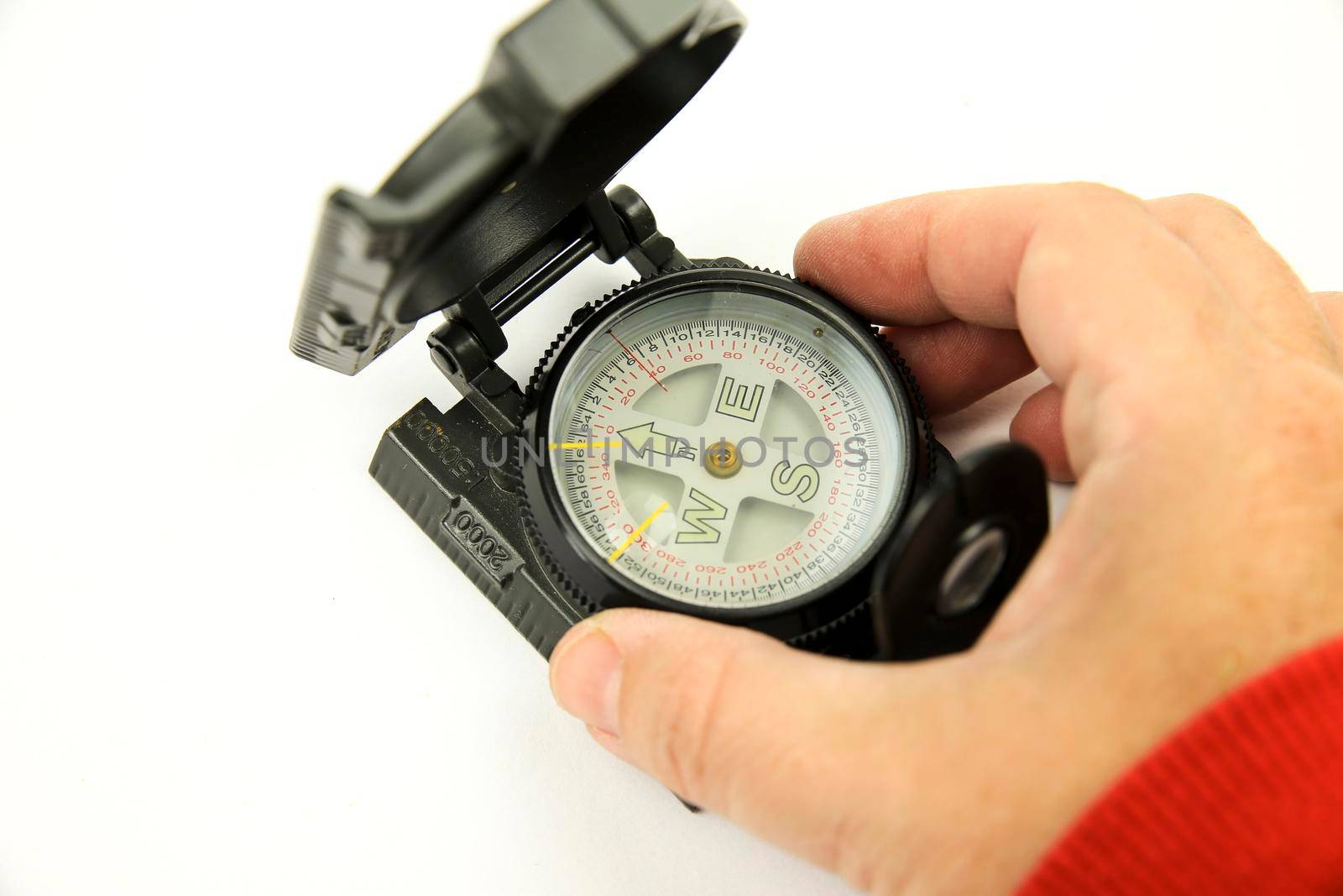Hand holding a Military green compass on white background