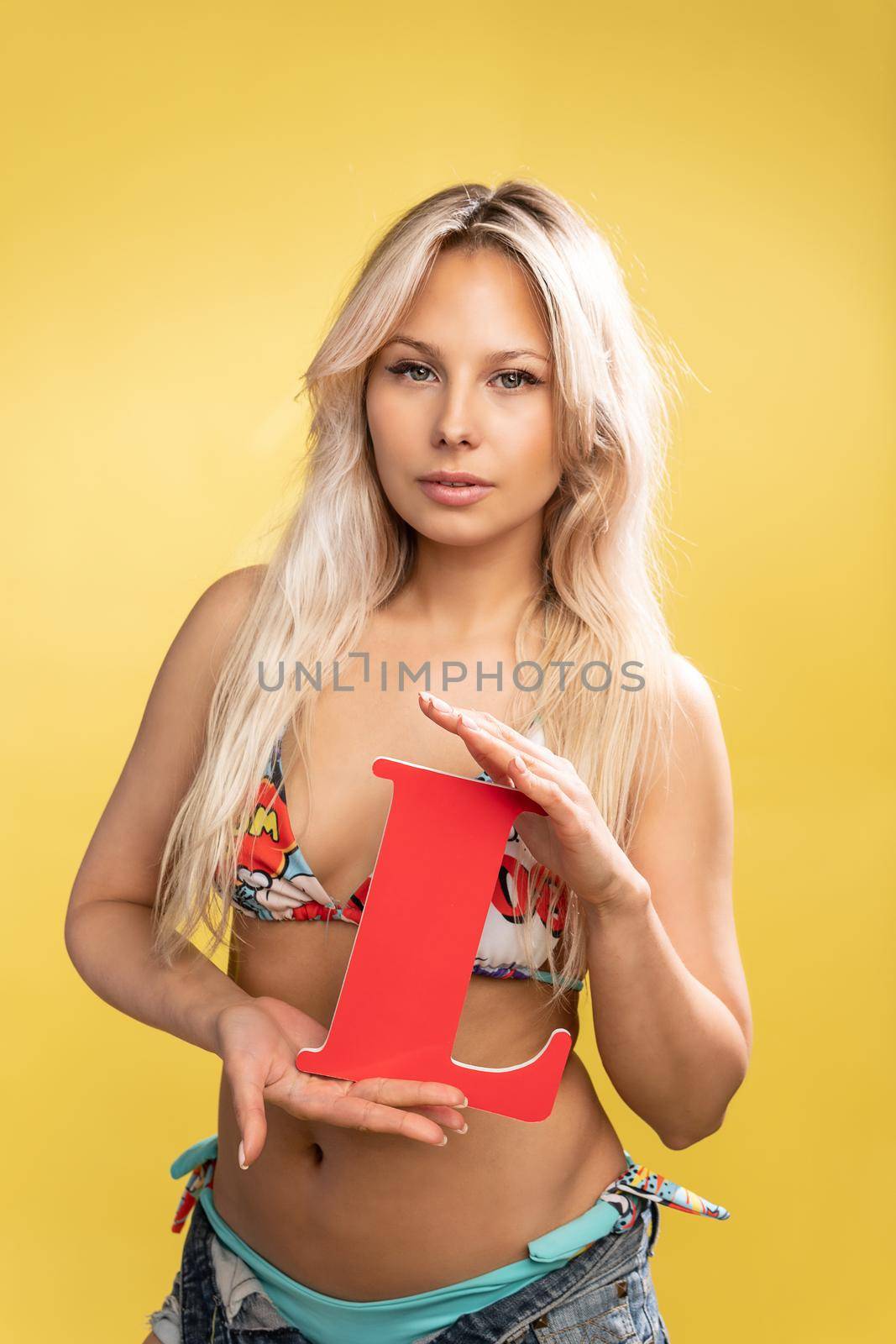 Girl holds the letters of the alphabet word love on a yellow background blonde beautiful smiles yellow creative beautiful, mockup pigtails schoolgirl smile, happy green. Cute education copy elementary woman L