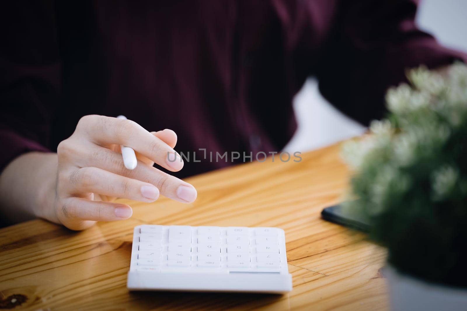 A female company employee is using a calculator to calculate sales income