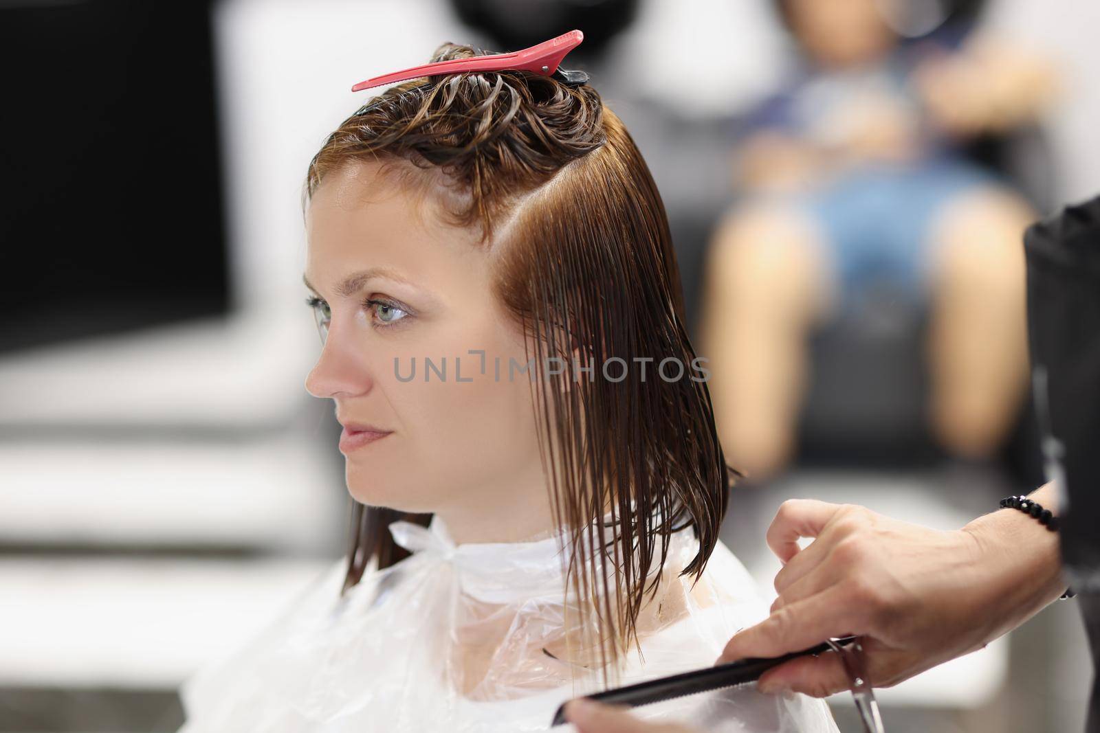 Portrait of female client with dry wet hair after beauty procedure, professional hair master in work. Wellness, beauty, change image, barbershop concept