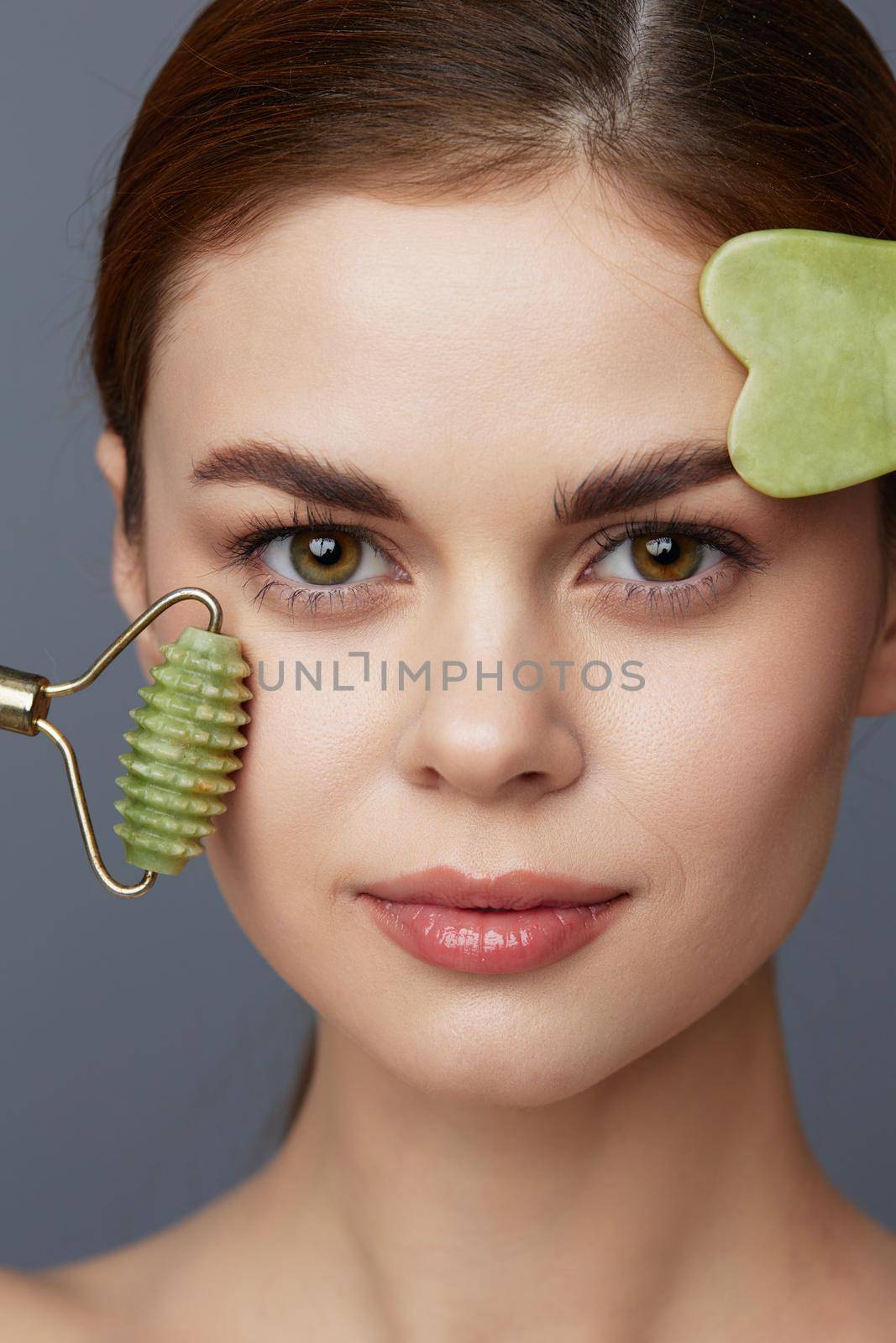 young woman jade face massager wrinkle smoothing close-up Lifestyle. High quality photo