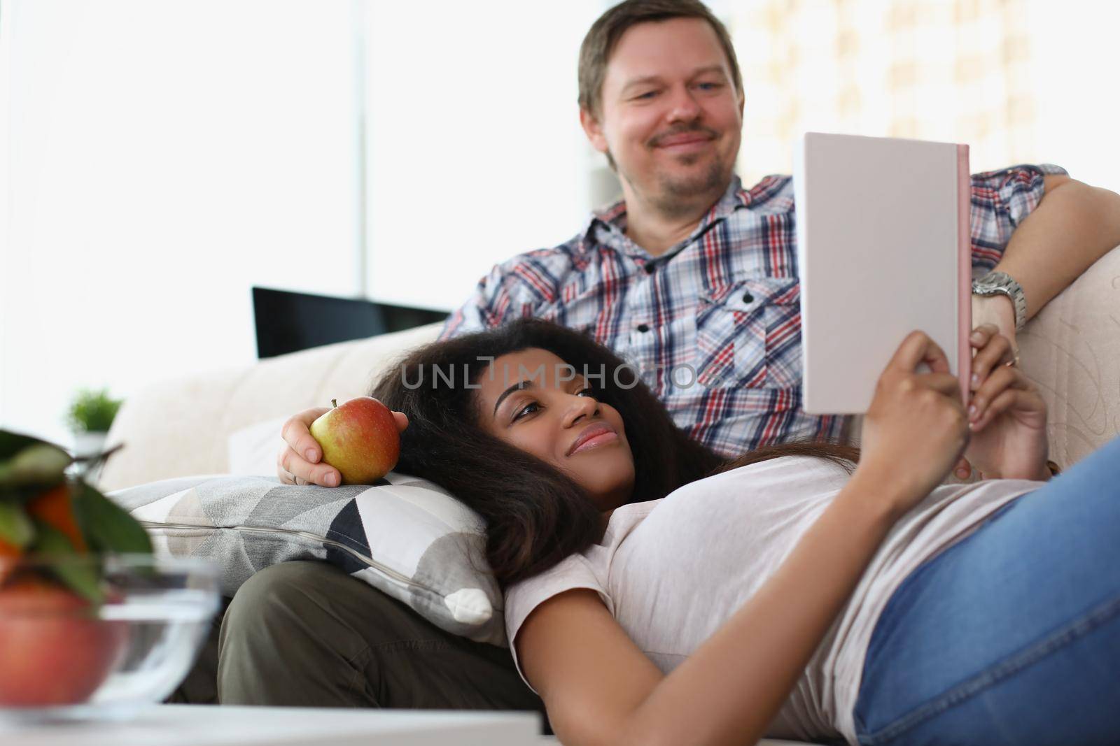 Portrait of middle aged man and young latin woman reading book together, good friends meet for fun. Happy quality time, friendship, hobby, leisure concept