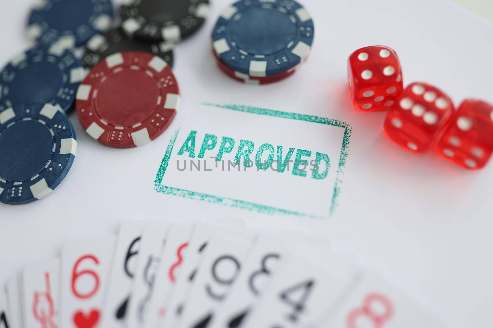 Close-up of stamp approved standing near playing cards and chips in casino with dice. Addiction, player, entertainment, winner, game, fun, luck concept