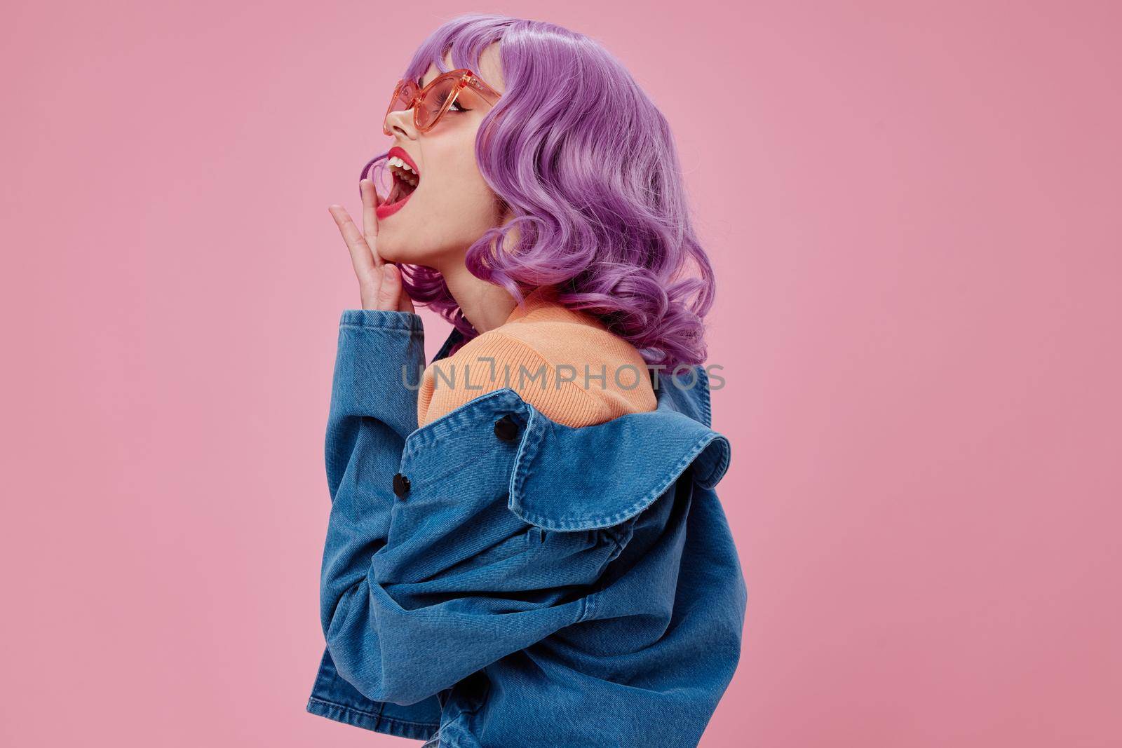 Beauty Fashion woman purple hair fashion glasses denim clothing pink background unaltered. High quality photo