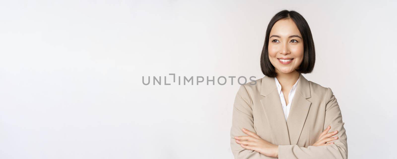 Confident female entrepreneur, asian business woman standing in power pose, professional business person, cross arms on chest, standing over white background.