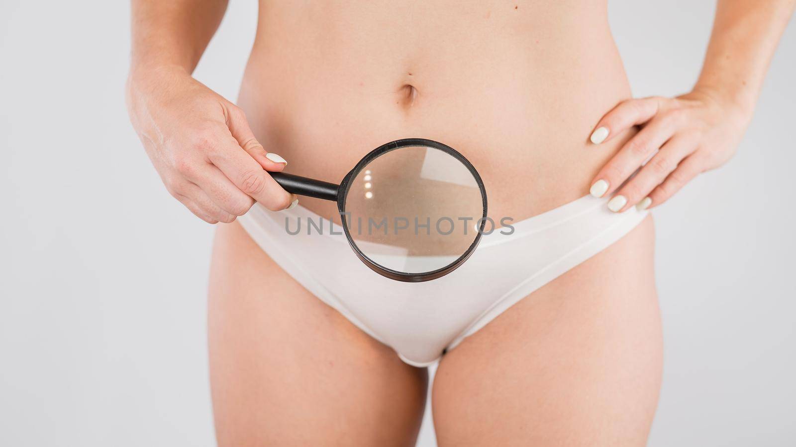A woman in white shorts holds a magnifying glass on a white background