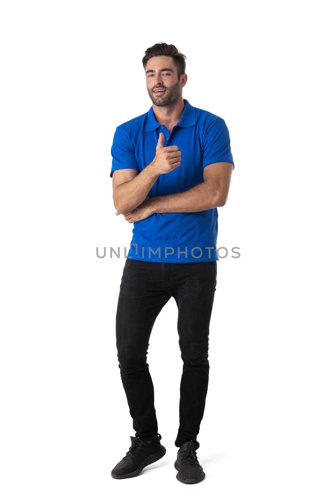 Full length portrait of casual young man standing and showing thumb up isolated over white background
