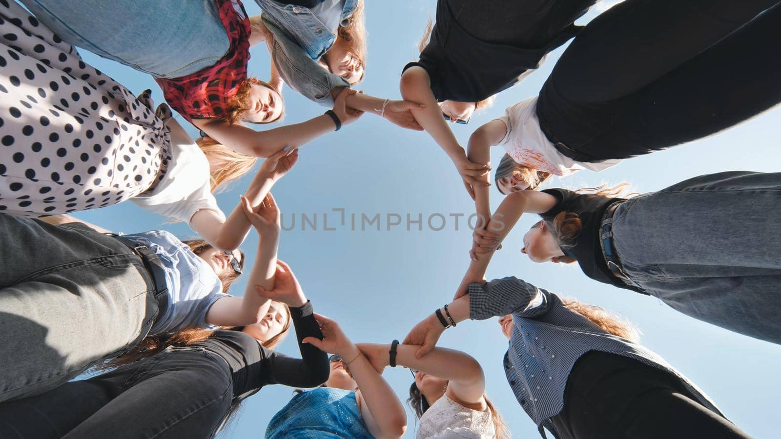 A group of girls makes a circle shape holding each other's hands