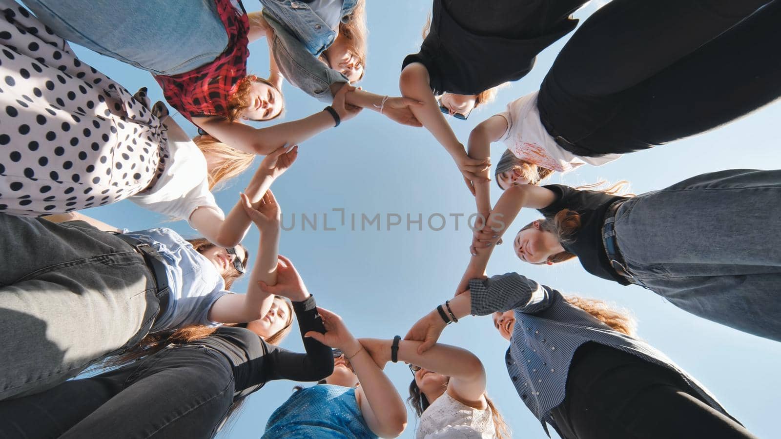 A group of girls makes a circle from their palms hands