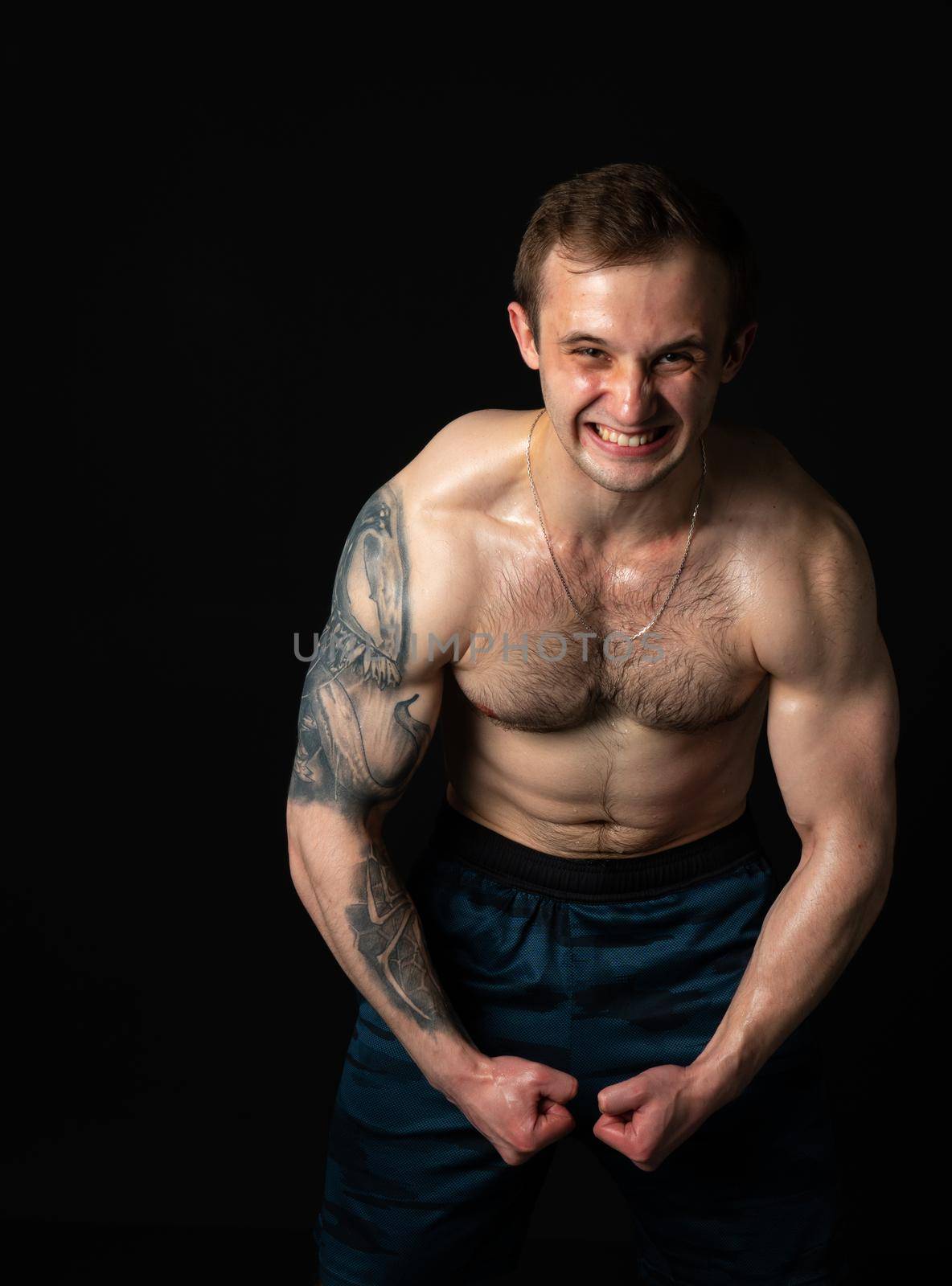 Man on black background keeps dumbbells pumped up in fitness active chest arm man bodybuilder dumbbell, male lifestyle. Lift handsome people fit strains the presbytery muscles