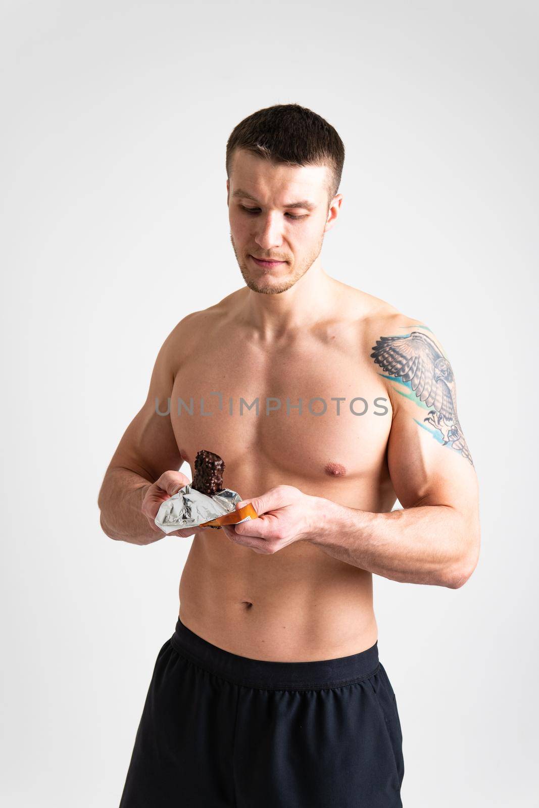 Man eats protein bar on white background isolated bar snack eat, taste health energetic outdoor ABS, cereal female