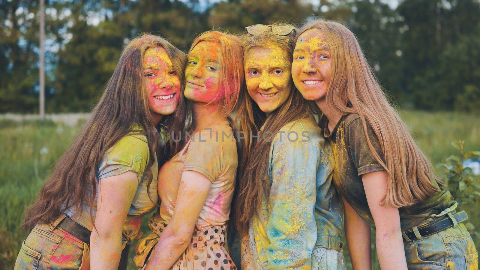 Cheerful girls posing smeared in multi-colored powder. by DovidPro
