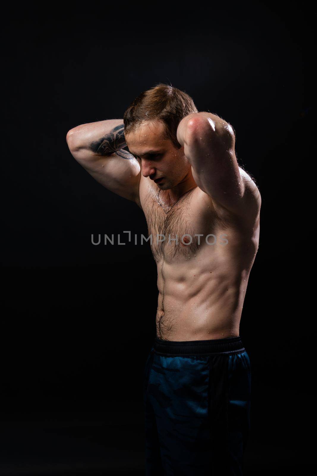 Man on black background keeps dumbbells pumped up in fitness muscle torso, arm weight fitness hold dumbbell, shirtless weightlifting. Young skin adult, people fit hands behind your head a beautiful press