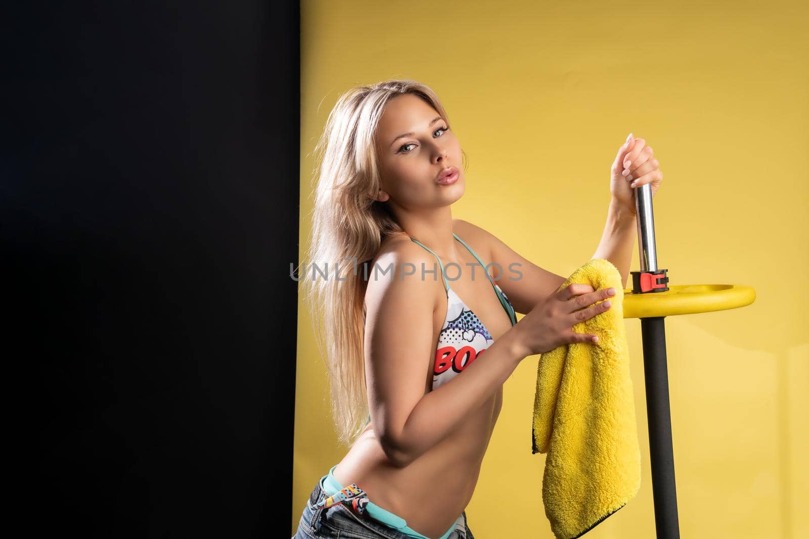 Girl on a yellow fitness background in a swimsuit washes the bar of the cleaning lady barbell gym workout, motivation sportswear healthy muscular lifestyle fun. bodybuilding lift, sportsman cleanliness by 89167702191