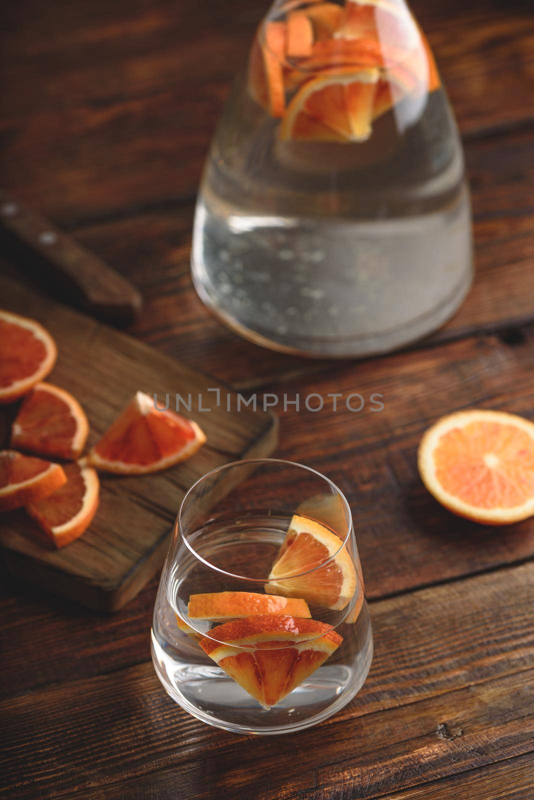 Infused water with bloody oranges in drinking glass