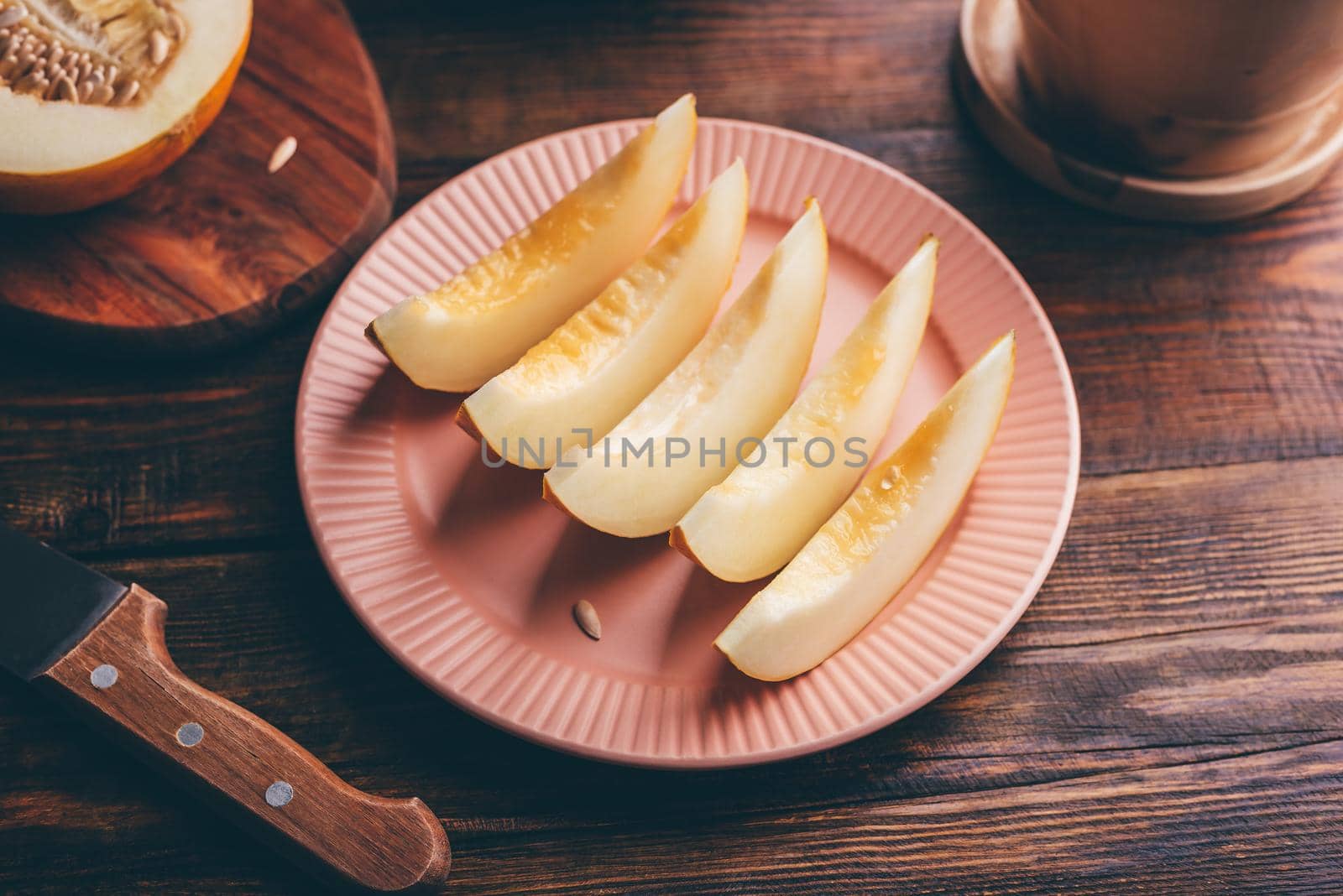 Plate of Sliced Ripe Yellow Melon on Rustic Wooden Table
