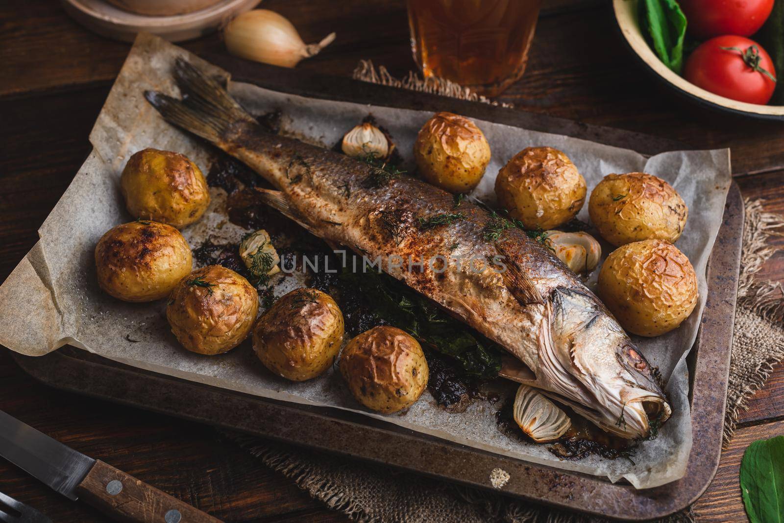 Sea Bass Stuffed with Sorrel and Baked with New Potatoes on Baking Tray