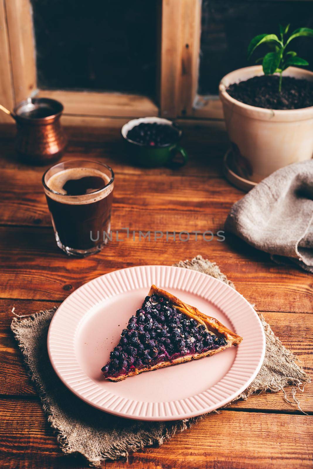 Slice of Fresh Baked Serviceberry Open Pie on Plate and Glass of Turkish Coffee on Wooden Table
