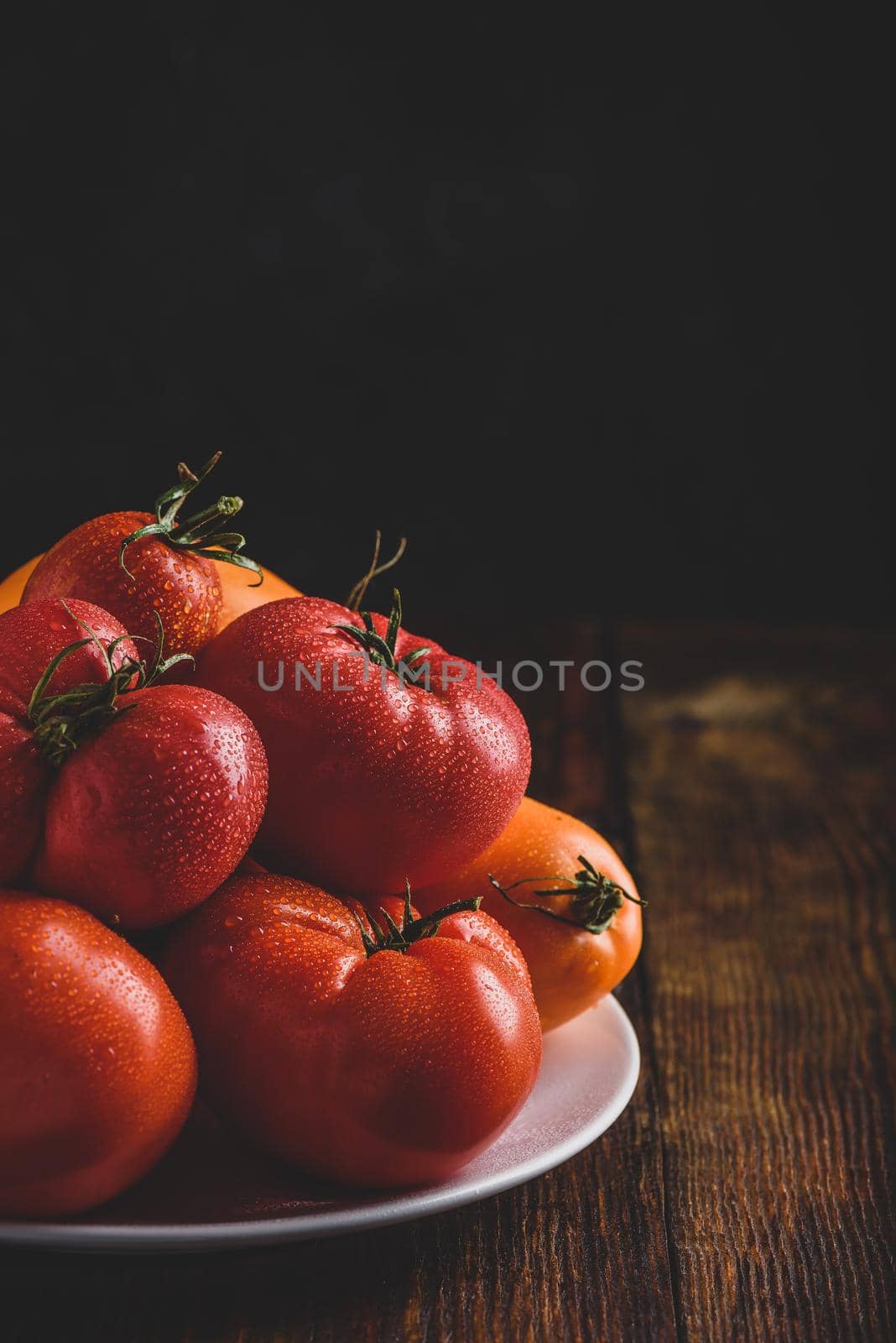 Fresh red and yellow tomatoes on plate by Seva_blsv