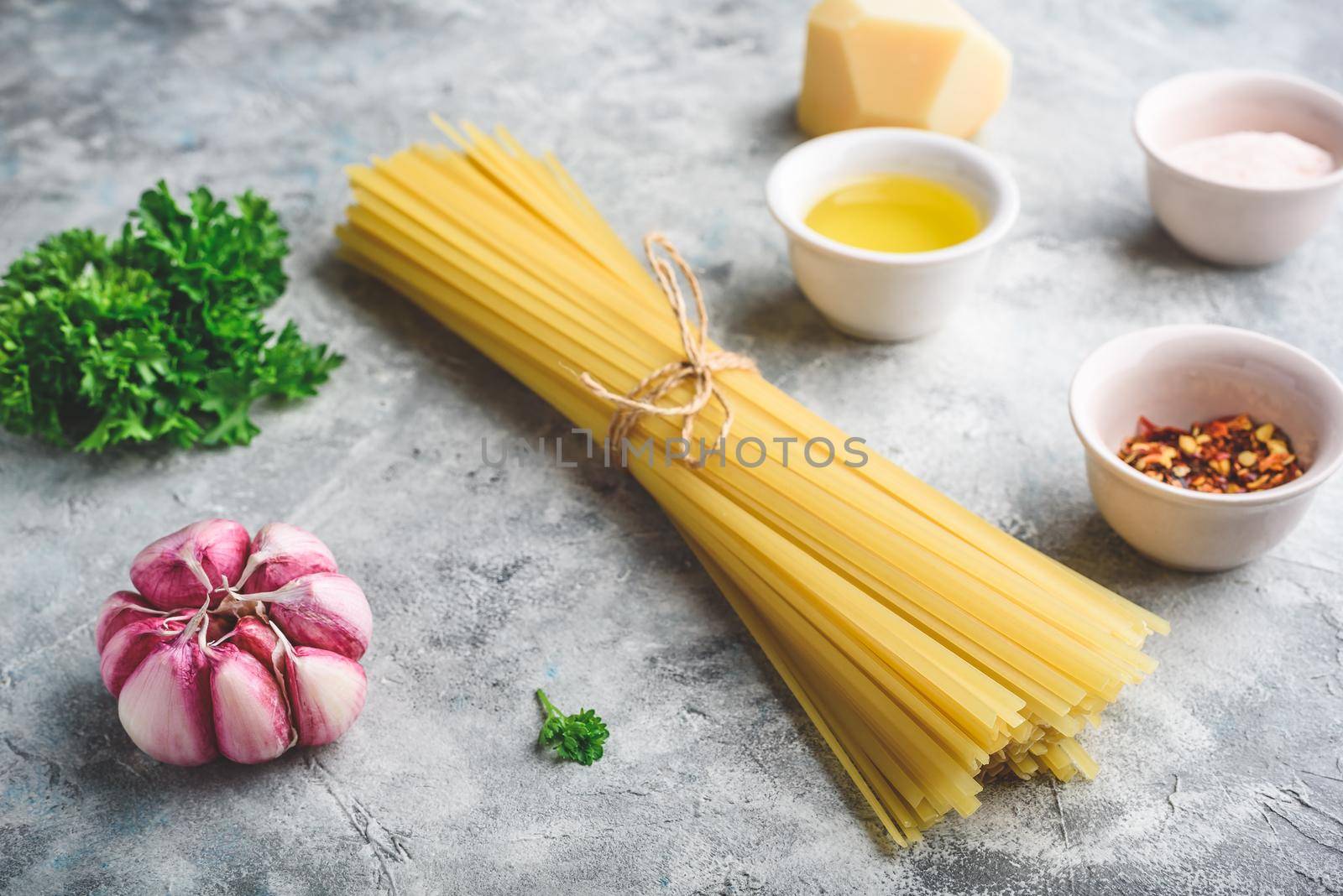 Raw ingredients for cooking linguine with olive oil, garlic and parsley