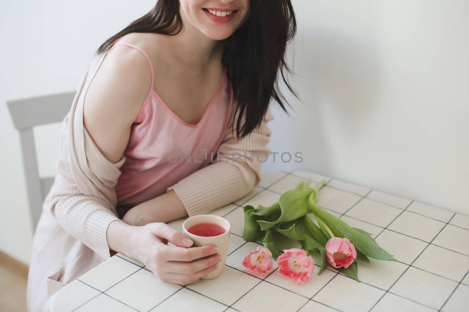 romantic tender portrait of a young woman with pink fresh tulips