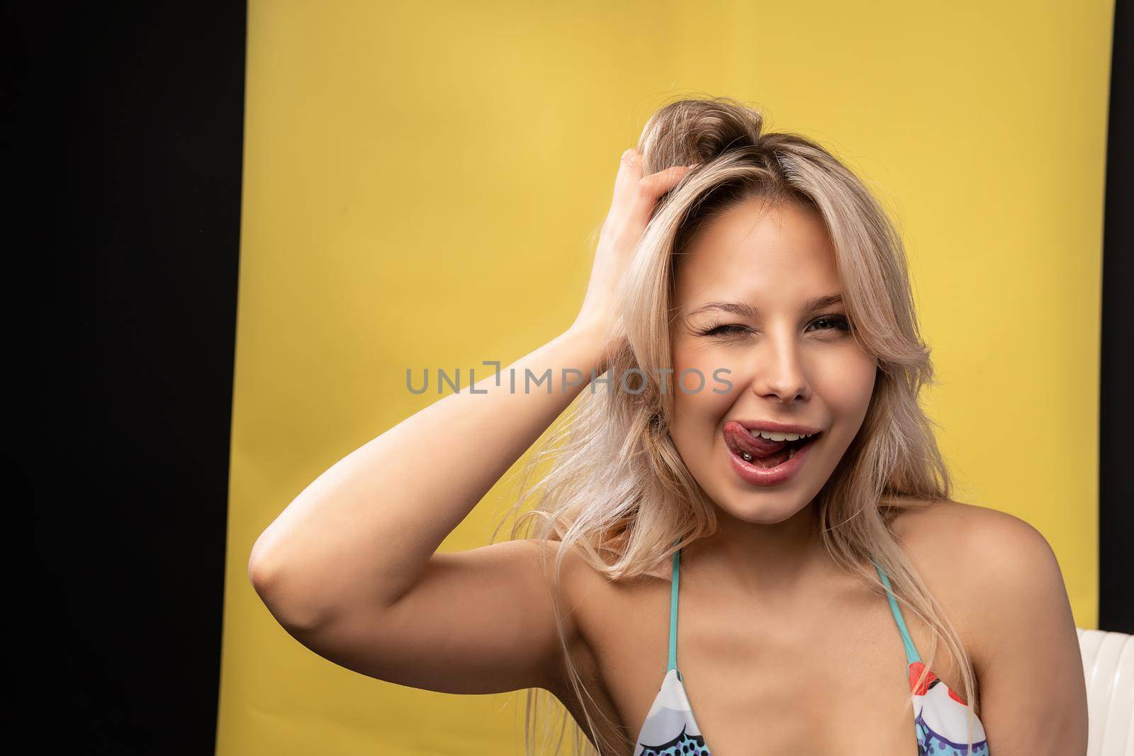 Girl keeps her head against a beautiful white background a beautiful smiles to have fun beautiful woman, young brunette style bodysuit, stylish wear. Beach suit sexy, model chair