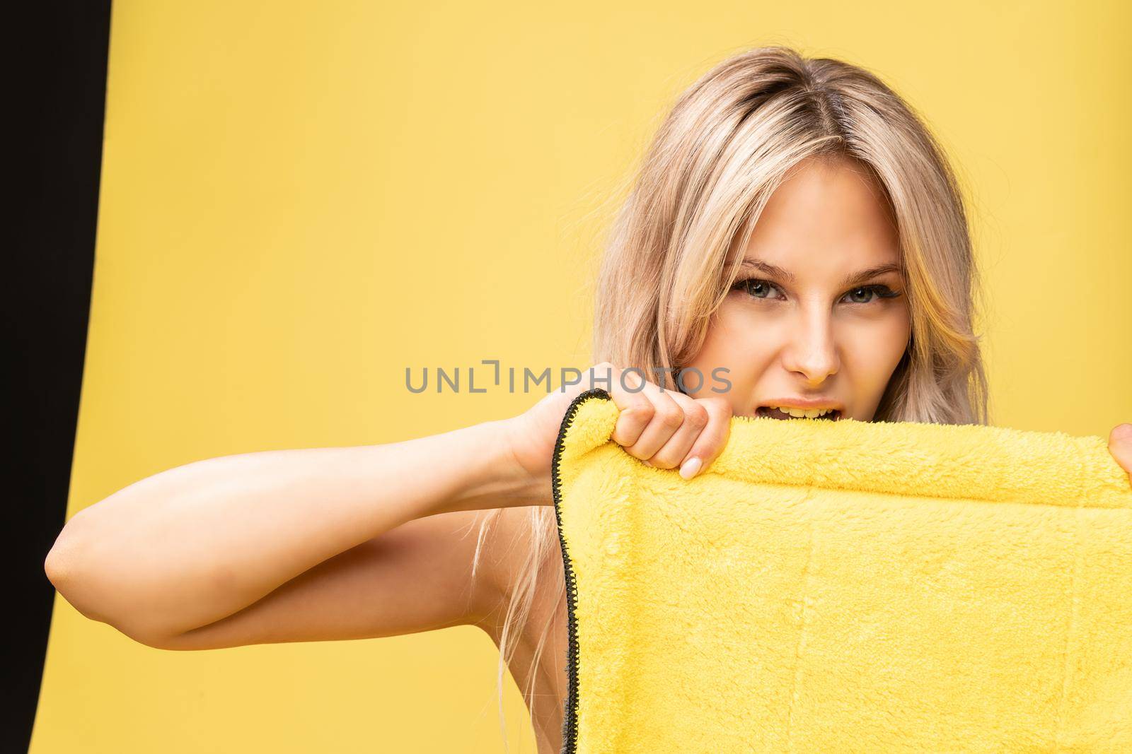 Girl rips rag with her hands yellow on a yellow background beautiful blonde dust maid, rubber protective hygiene clean virus, wiping cute. Helpful copy cleanly, woman around duties