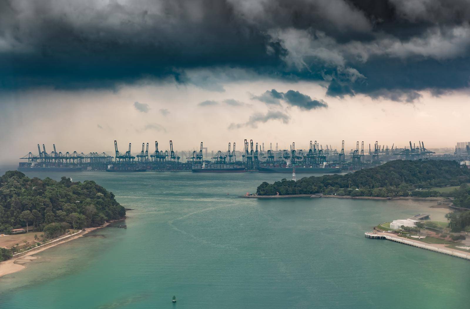 The huge busiest logistic port in Singapore, plenty of cranes to move containers, huge cargo ships in the background, skyscrapers on background. High quality photo