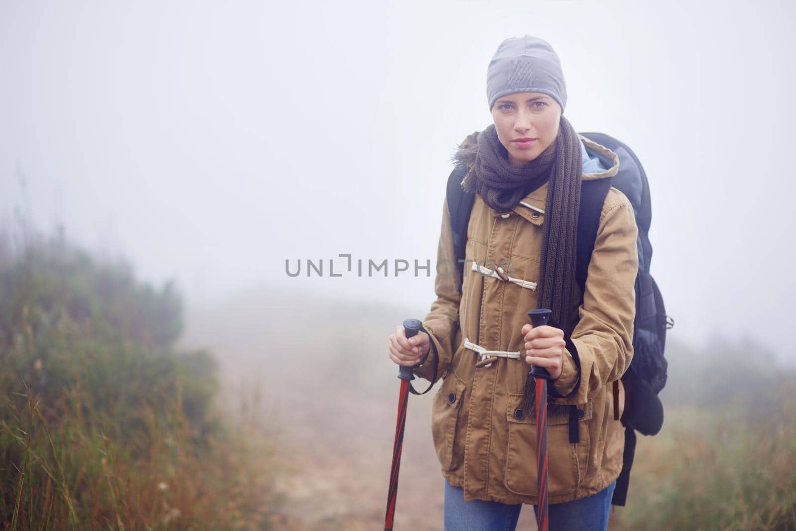 Portrait of a young woman hiking along a trail on an overcast day.