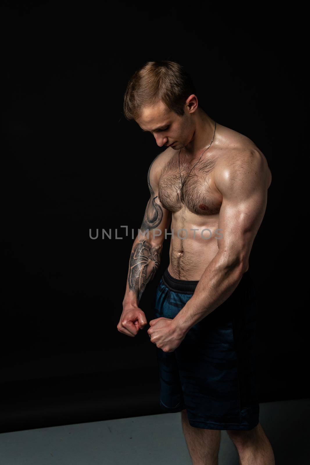 Man on black background keeps dumbbells pumped up in fitness muscle torso, arm training man bodybuilder hand, male pectoral. human fit beautiful press with hair