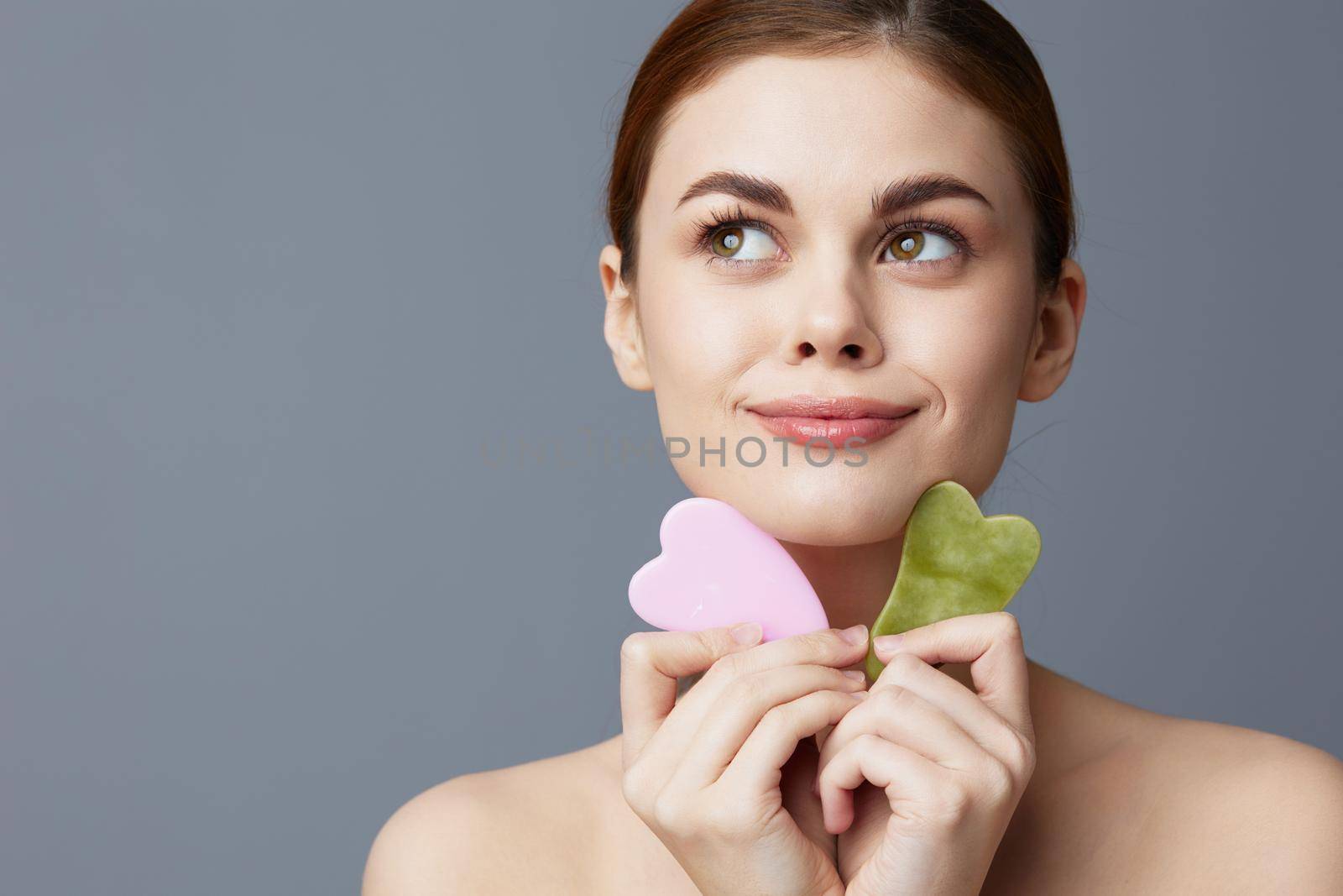 woman facial scraper skin care posing isolated background. High quality photo