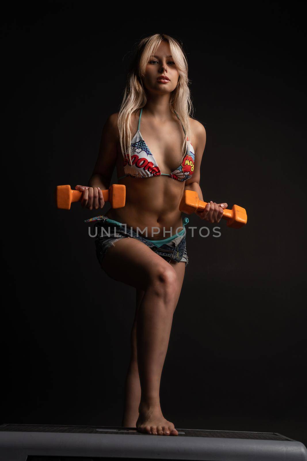 Dumbels Girl Step Platform Orange on Black Blonde active health legs, sport trainer gym girl, aerobic class. Body young beauty