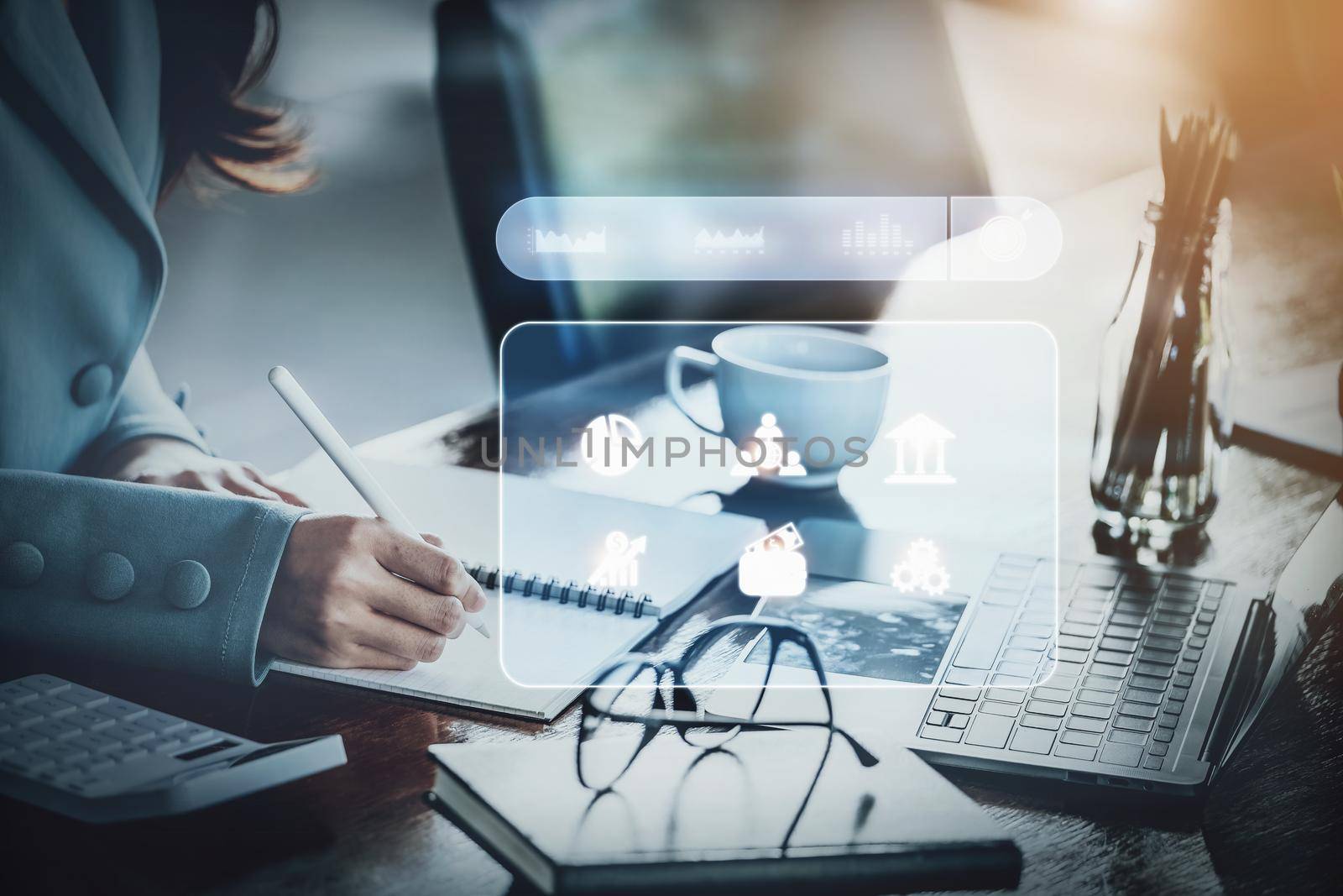 Finance and Investment Concepts Businesswoman holding a pen with note book and computer to study investment information and analyze stock market direction to manage investment risks. by Manastrong